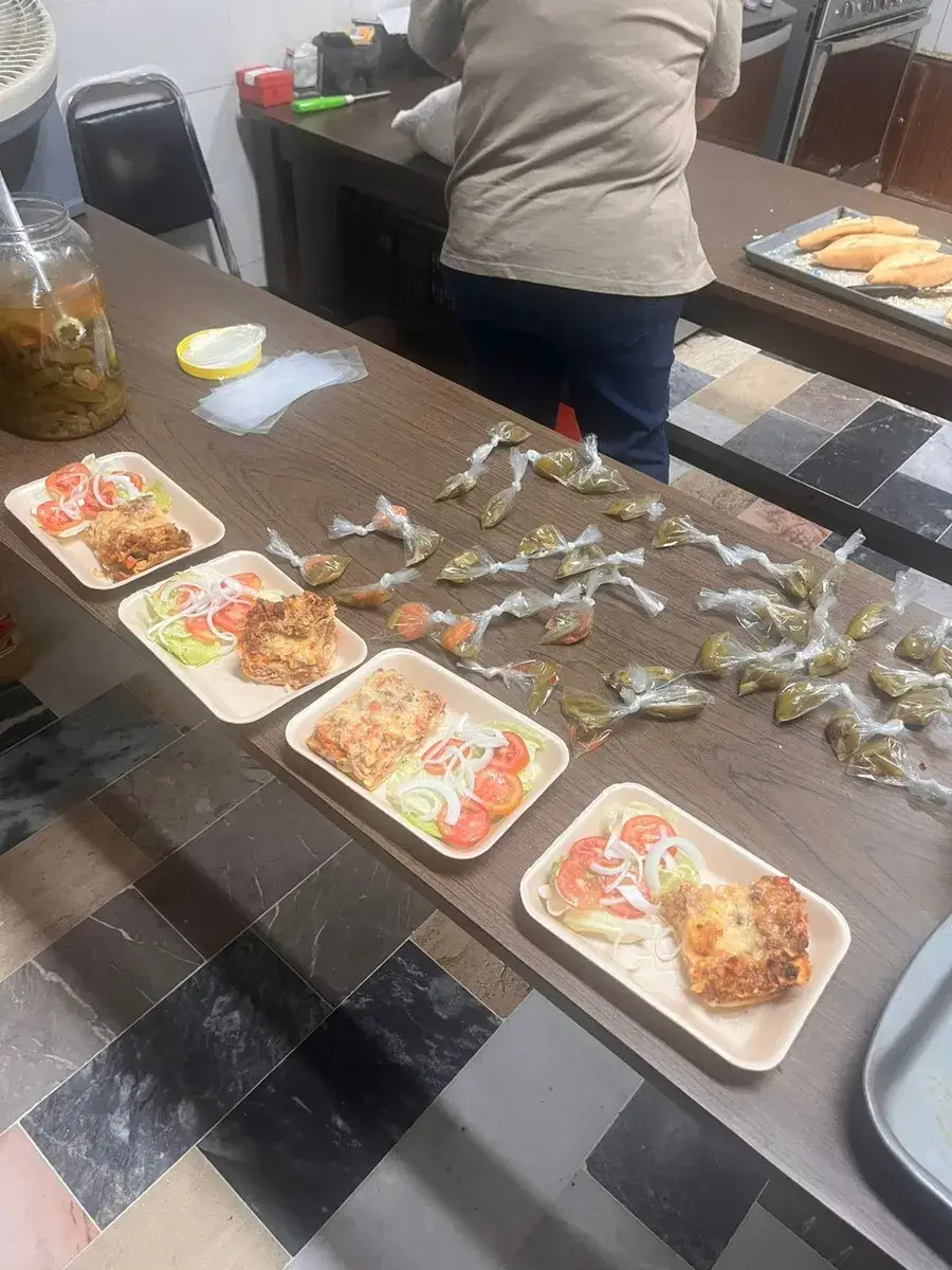 Charolas con comida servida y bolsas de alimento listas para entregar